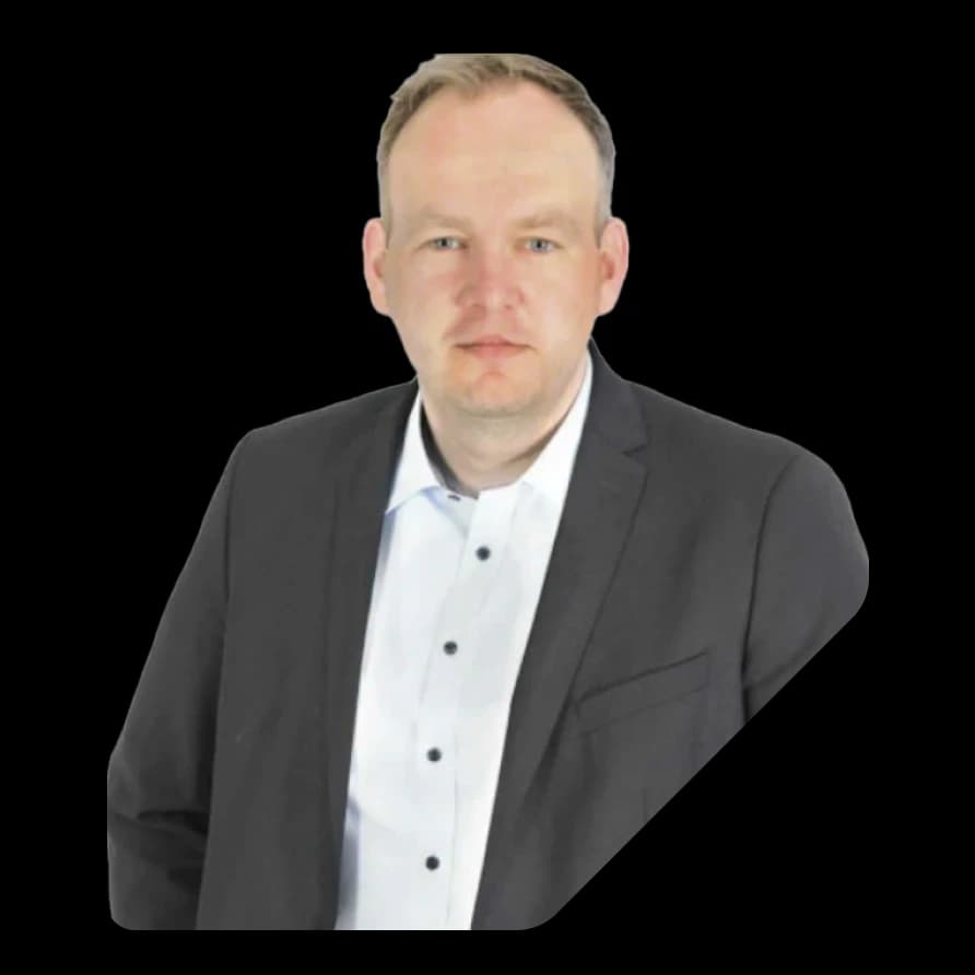Portrait of Sascha Breithecker in a dark blazer against a geometric black background