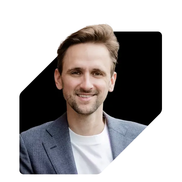 Porträt von Christian Weiss vor einer schwarzen geometrischen Form